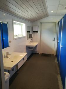 a bathroom with a sink and a toilet and a mirror at Fjellstova Ørskogfjellet Cottages in Sjøholt