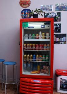 um frigorífico vermelho cheio de muitas bebidas em Lodge Hostel Piracicaba em Piracicaba