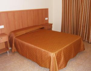 a bedroom with a bed with a brown cover on it at Apartamentos Cibeles in Roquetas de Mar