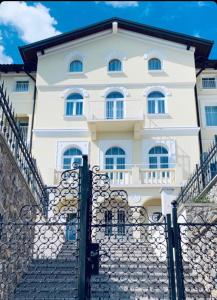 a white house behind a stone fence at Hotel Domino in Opatija