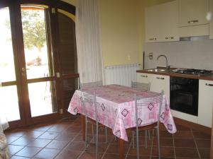 una cocina con una mesa con un mantel rosa. en Agriturismo La Dolce Collina, en Follonica