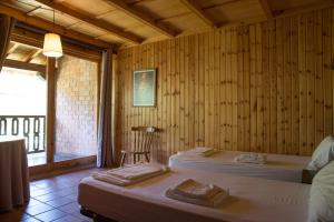 een kamer met 2 bedden, een stoel en een raam bij Albergue La Cabaña in Turieno