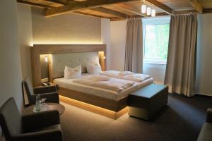a bedroom with a large bed and a window at Hotel Restaurant Große Teichsmühle in Dülmen