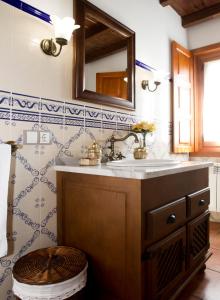 a bathroom with a sink and a wooden stool at Apartamentos Porcia in Tapia de Casariego