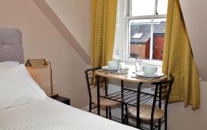 uma pequena mesa com duas cadeiras em frente a uma janela em Paton Cottage em Inverness