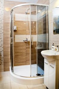 y baño con ducha y lavamanos. en Sun and holidays apartament Władysława IV, en Gdynia