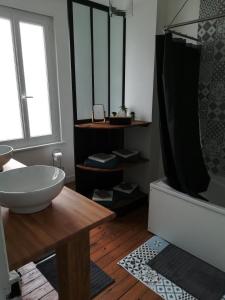 費康的住宿－L Alchimie，浴室配有盥洗盆和浴缸。