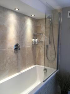 een badkamer met een douche en een bad bij No 1 Fairbank in Kirkby Lonsdale