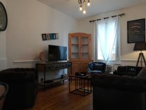 a living room with two couches and a television at L Alchimie in Fécamp
