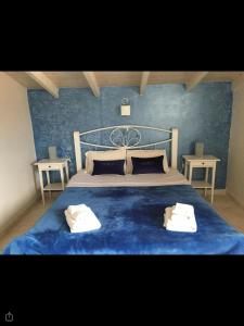 1 dormitorio azul con 1 cama con 2 toallas en Studios Meliton, en Porto Koufo