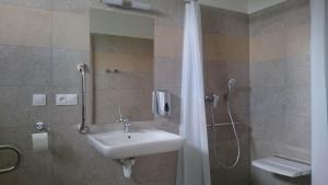 y baño con lavabo y ducha con espejo. en Penzion Skalka en Skalka
