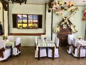 a dining room with tables and chairs with flowers on the wall at Mіnі Gotel Pozitiv in Horodets'ke