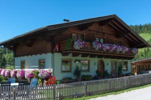 a house with flowers in front of it at Kleinwidmoos-Apartment in Wagrain