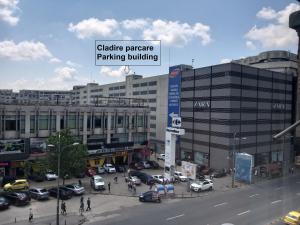 una città con auto parcheggiate in un parcheggio di Domum Unirea, across the street of Old City Center a Bucarest