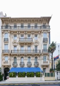 Un edificio con un tendone blu davanti di Nice Excelsior Centre ville by HappyCulture a Nizza