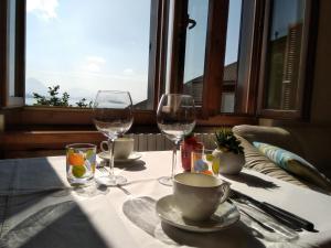 a table with two glasses of wine and a table with a window at Casa Bellavista - Lake Maggiore view and garden in Baveno