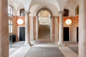 un couloir avec colonnes et escaliers dans un bâtiment dans l'établissement Combo Venezia, à Venise