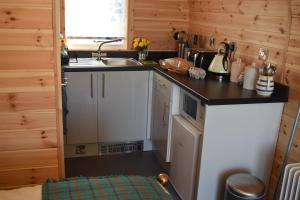 a small kitchen with a sink and a stove at The Beach Bothies in Valtos