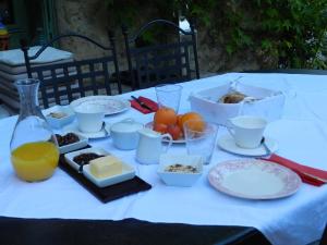 una mesa con platos de comida y una botella de zumo de naranja en Les Acanthes en Lauris