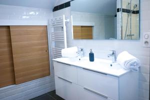 La salle de bains blanche est pourvue d'un lavabo et d'un miroir. dans l'établissement BUGEAUD #8 - Eden confidentiel - 2 chambres, à Brive-la-Gaillarde