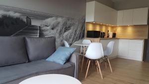 Apartament Fala Gardenia Seaside في جيفنوف: غرفة معيشة مع أريكة ومطبخ