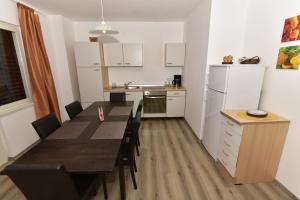 cocina con mesa de comedor y cocina con electrodomésticos blancos en Apartment Hemingway, en Malinska