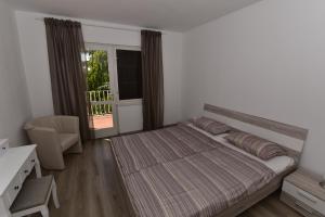 1 dormitorio con cama, escritorio y ventana en Apartment Hemingway, en Malinska