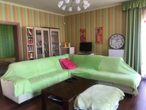 a living room with a green couch and a table at Nyaralo Balatonszárszó in Balatonszárszó