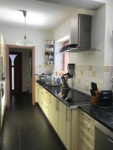 a kitchen with yellow cabinets and a black counter top at Nyaralo Balatonszárszó in Balatonszárszó +4 photos