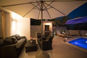 a living room with a couch and an umbrella at Villa Sunset in Kastel Novi +32 photos
