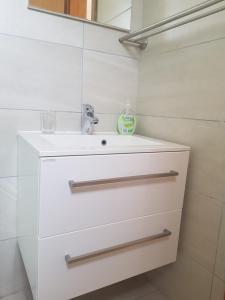 a white bathroom with a sink and a mirror at Studio Apartment Sanja 3 in Neum