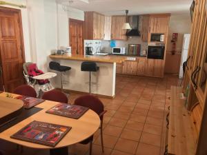 a kitchen with wooden cabinets and tables and chairs at Hacienda de Lula in El Campello