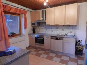 a kitchen with stainless steel appliances and a window at Kleinwidmoos-Apartment in Wagrain