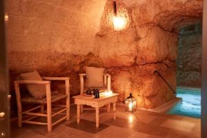 a room with two chairs and a table in a cave at Musae Relais & SPA in Polignano a Mare