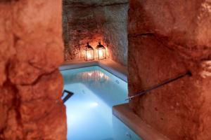 a swimming pool with lights in a cave at Musae Relais & SPA in Polignano a Mare