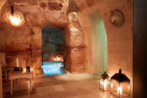 a room with a pool in a cave with lights at Musae Relais & SPA in Polignano a Mare