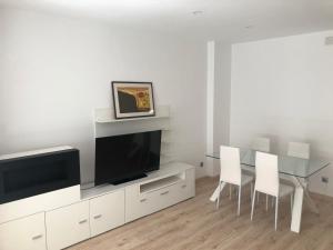 ein Wohnzimmer mit einem Esstisch und einem TV in der Unterkunft ÀTIC Mercat Central in Tarragona