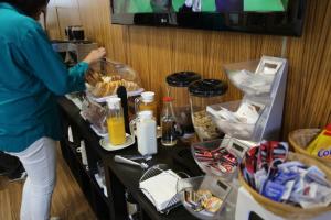 a woman preparing food on a table in a room at Hotel Alda Estación Pontevedra in Pontevedra