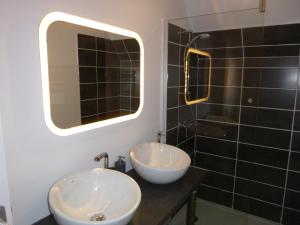 baño con 2 lavabos y espejo grande en Le Bouddha Besse, en Besse-et-Saint-Anastaise