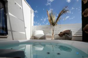 a swimming pool with a table and chairs on a patio at Musae Relais & SPA in Polignano a Mare