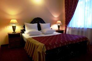 1 dormitorio con 1 cama con 2 lámparas y una ventana en Prestige Hotel, en Krasnodar