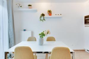 una sala da pranzo con tavolo e sedie bianchi di Royal Arts-Loi Studio a Bruxelles