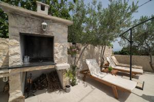 a stone fireplace with a tv and a couch at Villa Sunset in Kastel Novi