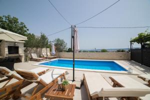 a pool with chaise lounge chairs and a swimming pool at Villa Sunset in Kastel Novi