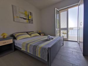 ein Schlafzimmer mit einem Bett und einem großen Fenster in der Unterkunft Yellow wish in Sobra