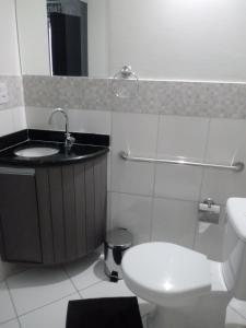 a bathroom with a toilet and a sink at Hotel Bellagio in Campo Grande