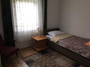 哥魯拜克的住宿－Apartmani Vidikovac，一间卧室配有一张床、一张桌子和一个窗户。