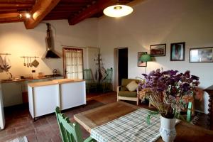 a kitchen and living room with a table and flowers at Casina Di Cornia in Castellina in Chianti