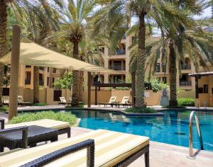 a swimming pool with palm trees and a hotel at Maison Privee - Luxury Living Next to Dubai Mall & Burj Khalifa in Dubai