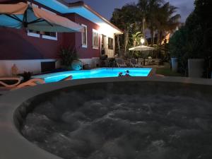 Un jacuzzi frente a una casa por la noche en Villa Margherita, en Pozzallo
